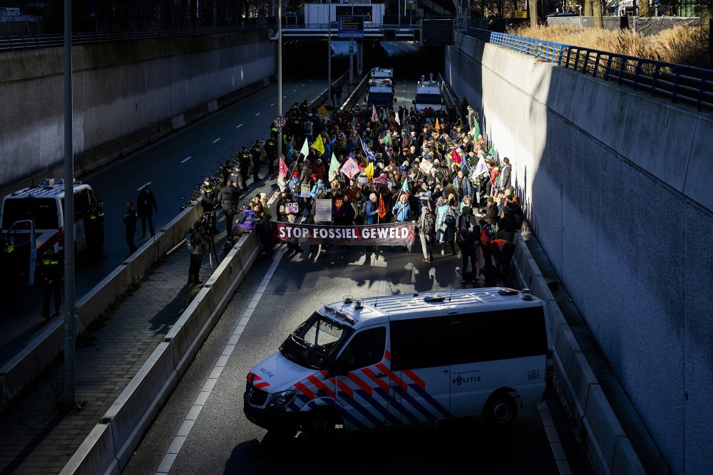 Klimaaktivisten halten während einer Blockade der Autobahn A12 in Den Haag ein Banner hoch, um von den Politikern ein Ende der Subventionen für fossile Brennstoffe zu fordern