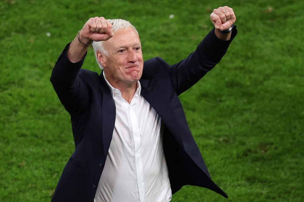 Frankreichs Nationaltrainer Didier Deschamps steht auf dem Fußballrasen und reckt freudig beide Hände in die Höhe