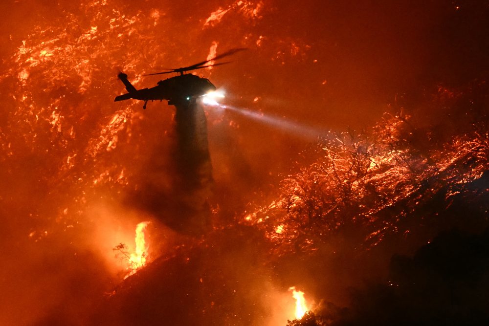 Ein Löschhubschrauber wirft über einem Brandgebiet in Los Angeles Wasser ab