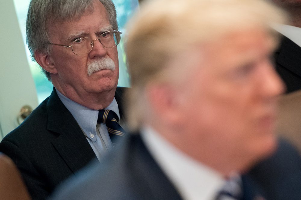 John Bolton steht hinter Donald Trump, während dieser gerade eine Ansprache hält