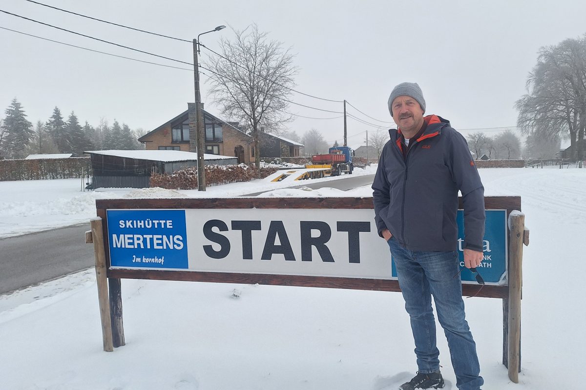 Günter Mertens von der Skihütte Mertens am Kornhof steht auf schneebedecktem Boden vor einem Schild mit der Aufschrift "Start"