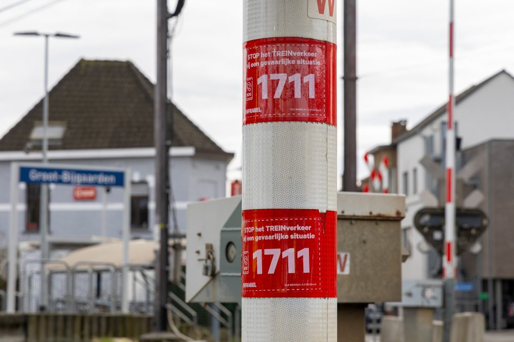 Aufkleber mit der Notrufnummer 1711 an einem Bahnübergang (