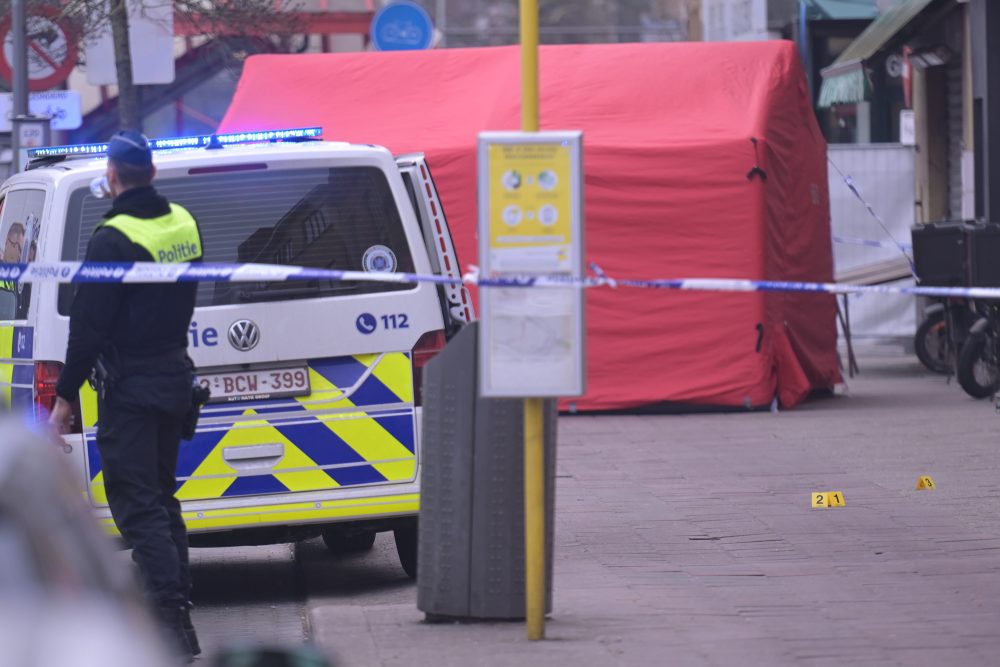 Der Tatort der tödlichen Messerstecherei in Antwerpen ist abgesperrt, man sieht einen Polizisten und ein Polizeiauto und im Hintergrund ein rotes Zelt