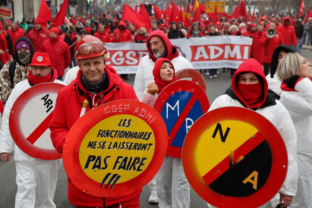 Demonstranten marschieren durch Brüssel, einige von ihnen halten Verkehrszeichen nachempfundenen Schilder in die Höhe