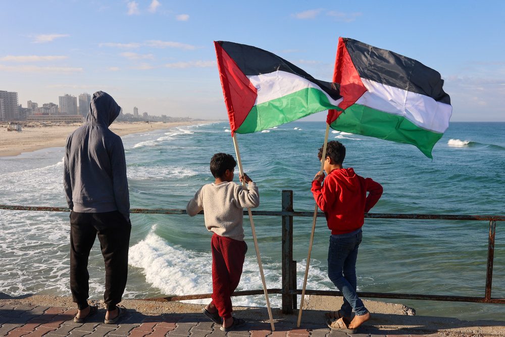 Jungen mit palästinensischen Flaggen an der Küste des Gazastreifens