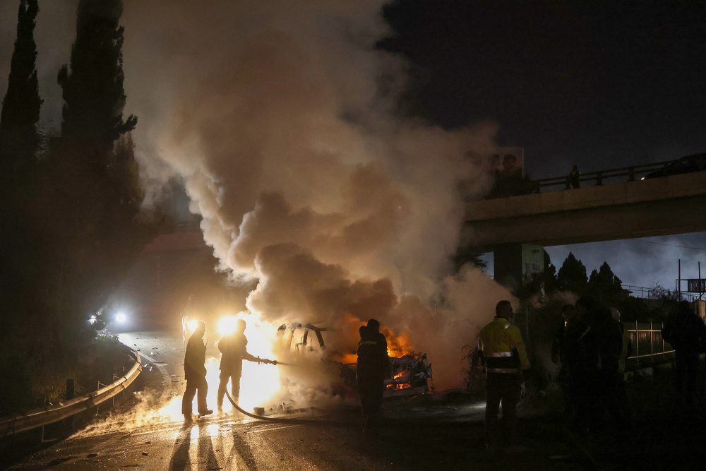 Feuerwehrleute löschen das brennende Unifil-Fahrzeug