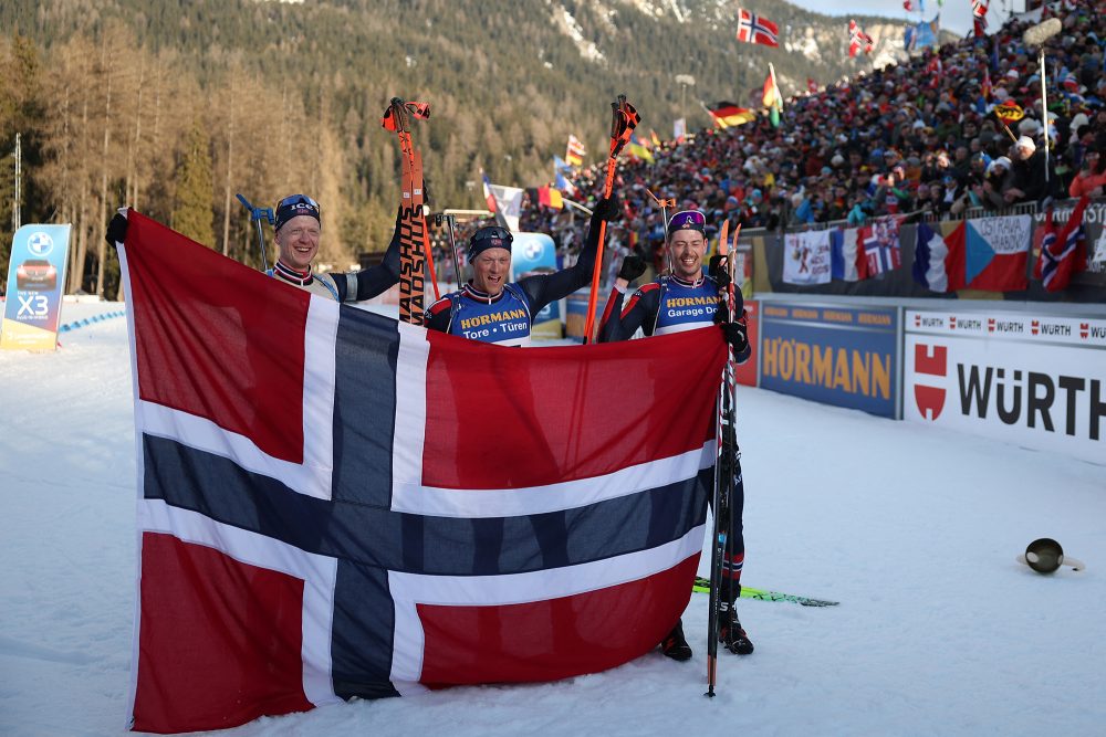 Massenstart-Treppchen: Johannes Thingnes Boe, Endre Stroemsheim und Sturla Holm Laegreid mit der norwegischen Flagge