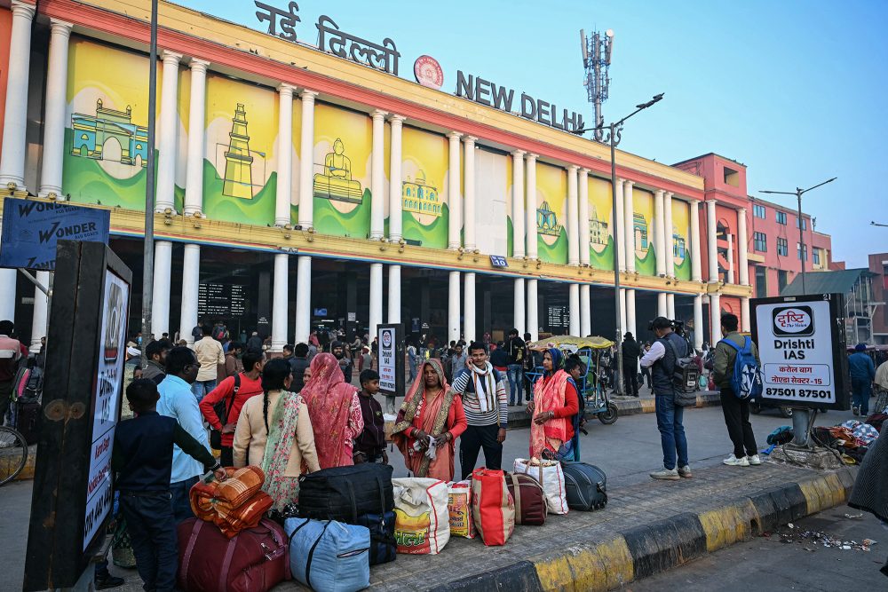 Passagiere warten vor dem Bahnhof von Neu-Delhi