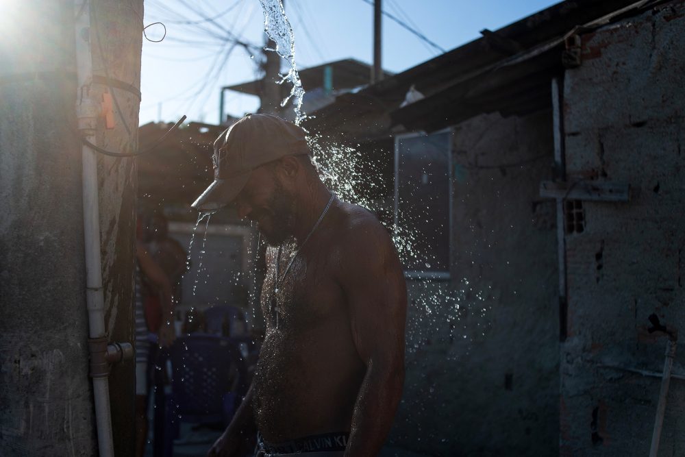 Mann nimmt eine kalte Dusche gegen die Hitze in Rio de Janeiro