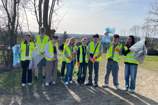 Die Schüler halten ihre Mülltüten demonstrativ in Richtung Kamera, um zu zeigen, wie viel Müll sie schon gesammelt haben