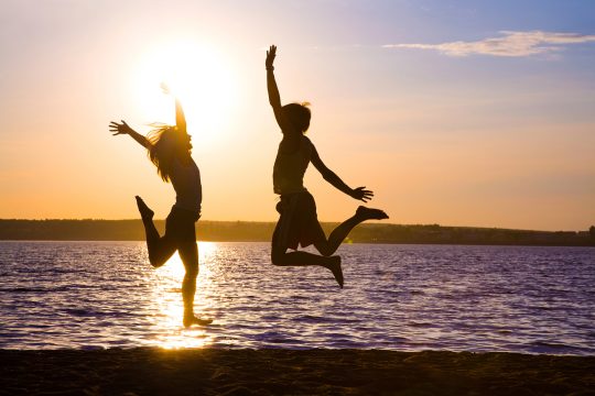 Frau und Mann bei Sonnenuntergang am Strand