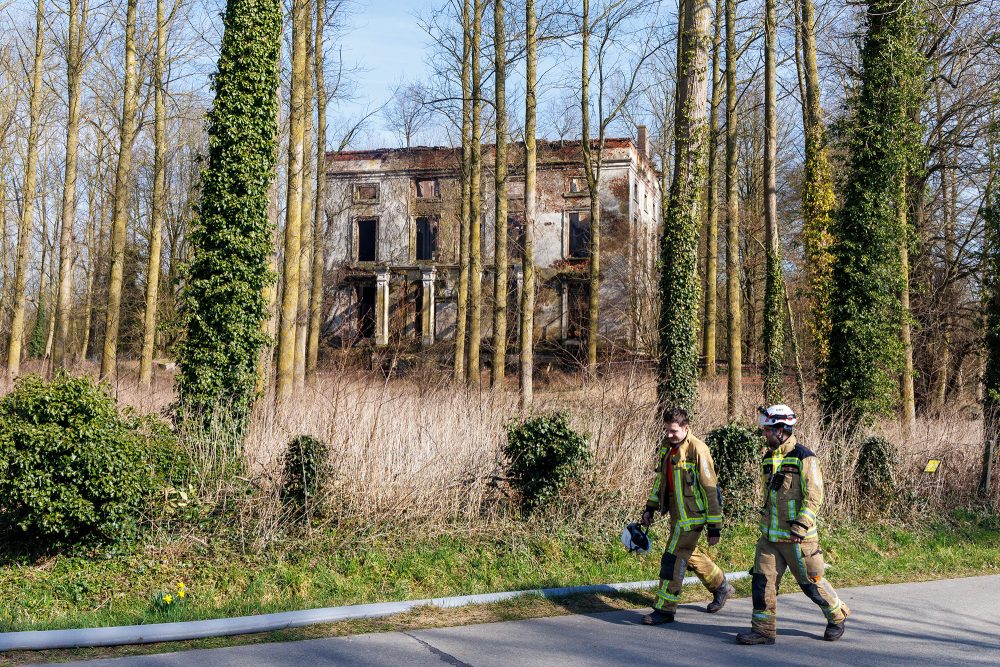 Feuerwehrleute vor dem Schloss van Moregem nach dem Brand