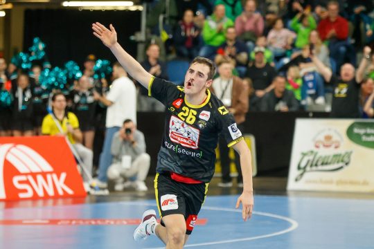 Nick Braun während eines Handballspiels - er hält einen Arm in die Höhe