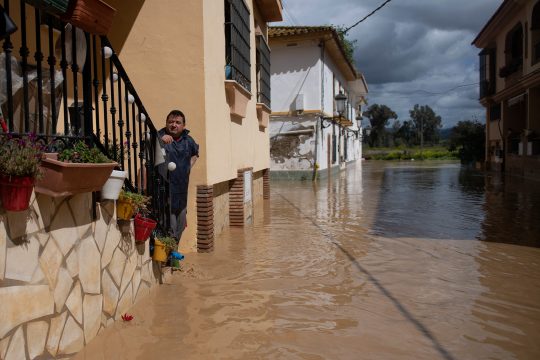 Anwohner steht in einer überfluteten Straße in Cartama bei Malaga