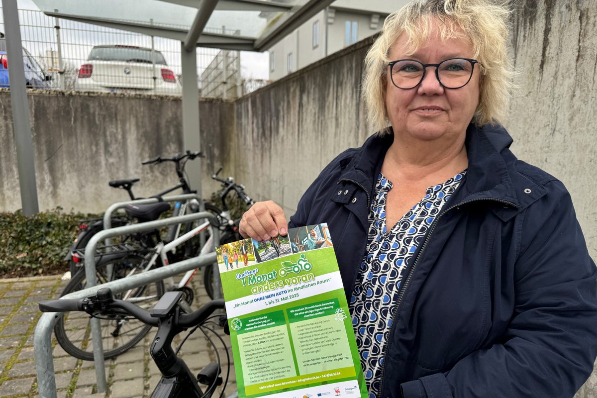 Claudia Schmitz von der VoG Fahr steht an einem Fahrradparkplatz und hält einen Infoflyer zu der Aktion in den Händen