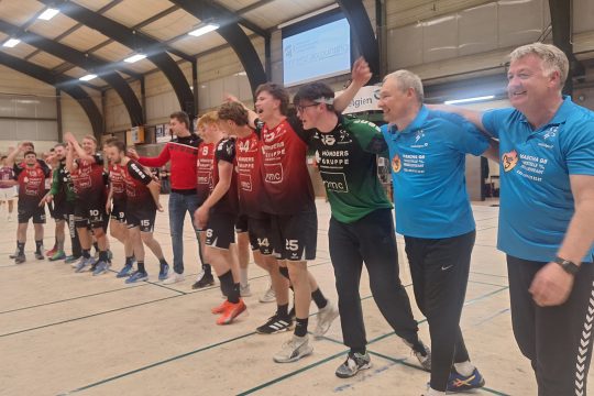 Spieler und Trainer posieren in einer Reihe und jubeln