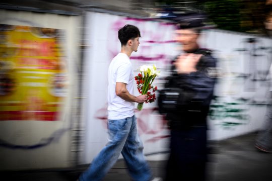 Schüler mit Blumen für die Opfer des Messerangriffs in Nantes