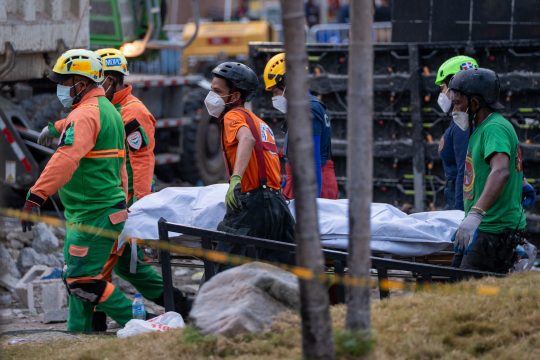 Rettungskräfte tragen eine Leiche aus den Trümmern