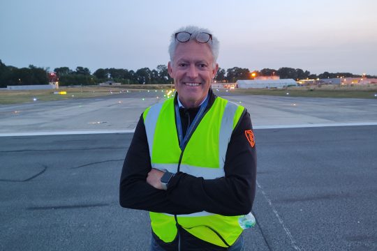 Philippe Verdonck steht in gelber Sicherheitsweste auf dem Rollfeld des Flughafens Charleroi