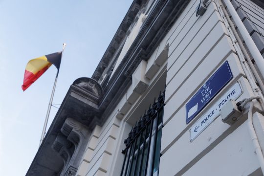 Belgische Flagge und Straßenschild der "Rue de la Loi" in Brüssel