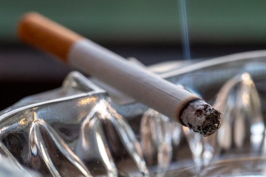 Qualmende Zigarette im Aschenbecher