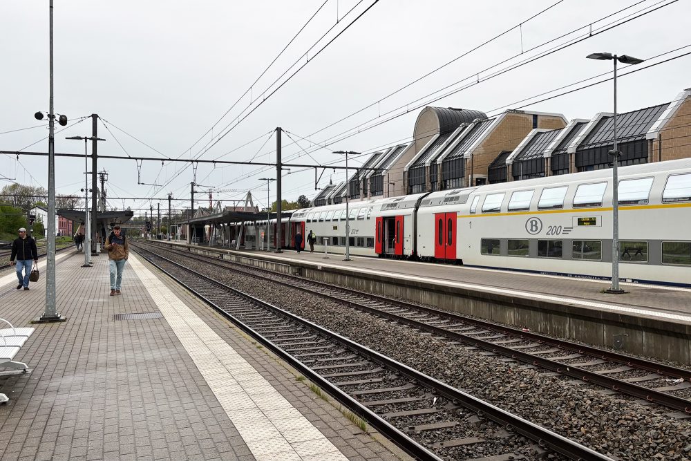 Reisende und ein Zug im Bahnhof Welkenraedt