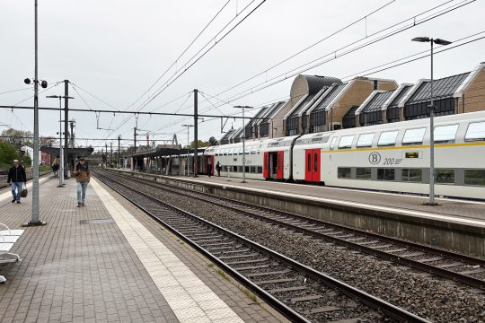 Reisende und ein Zug im Bahnhof Welkenraedt