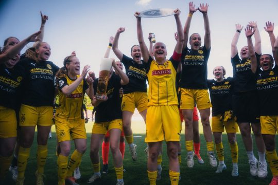 Die BVB-Frauen jubeln, eine Spielerin hält die Meisterschale hoch, eine andere hält ein großes gefülltes Bierglas in den Händen