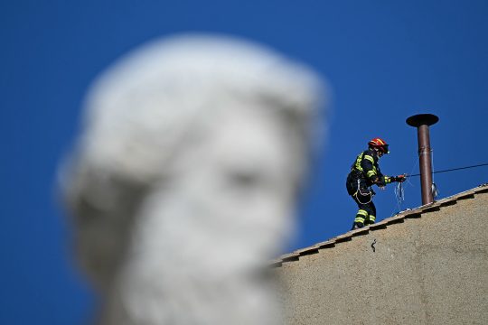 Feuerwehrmann installiert den Kamin auf der Sixtinischen Kapelle