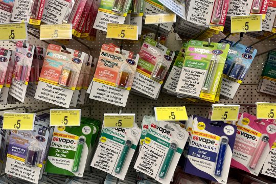 Eine Vielzahl von Einweg-E-Zigaretten mit unterschiedlichen Geschmacksrichtungen hängen an einem Regal