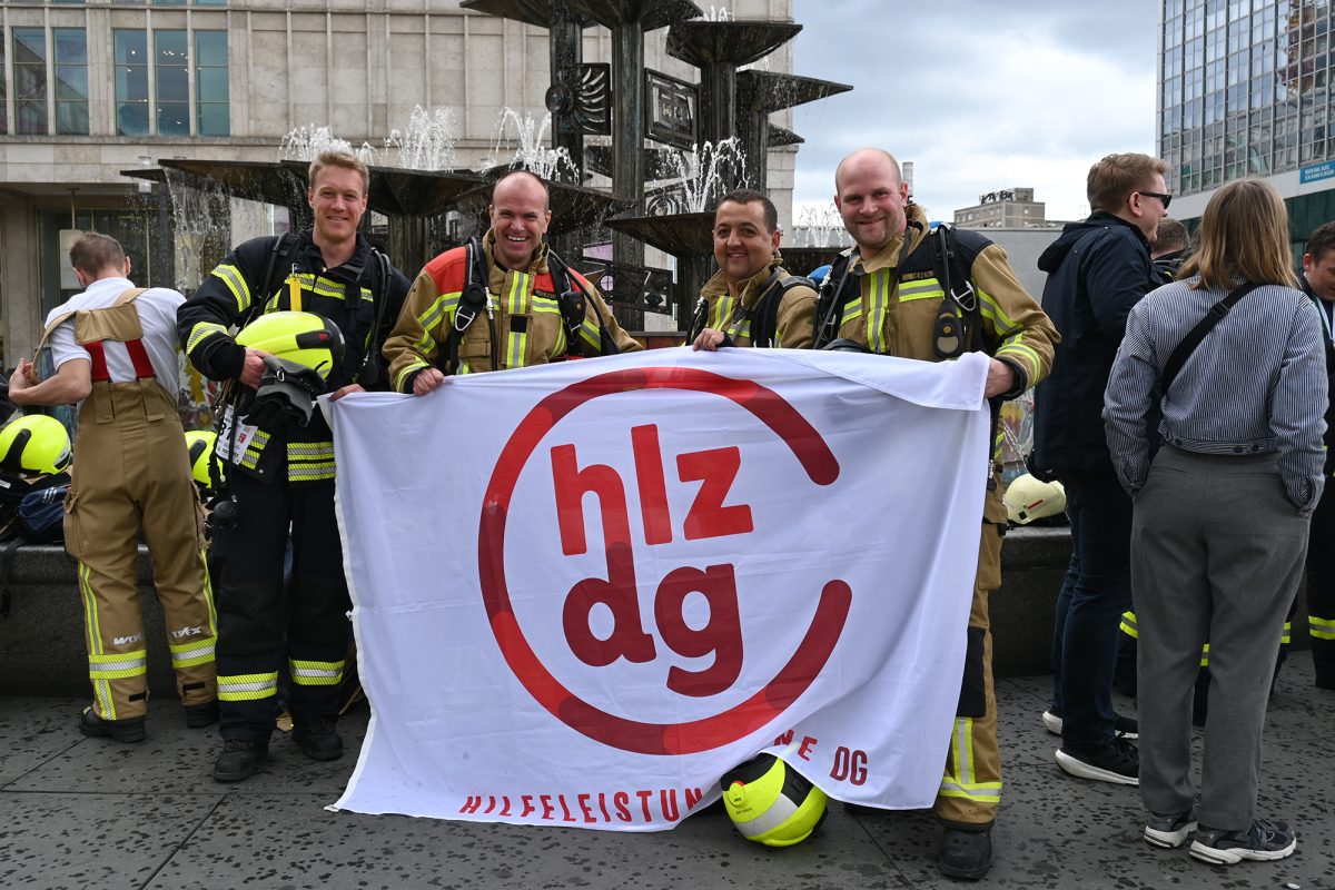 René Schoonbrood, Jörg Heinen, Daniel Klinges und Leif Daniels stehen auf dem Dach und halten die Flagge der Hilfeleistungszone DG in den Händen