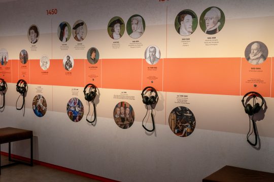 Erklärtafeln und Hörstationen an einer Wand