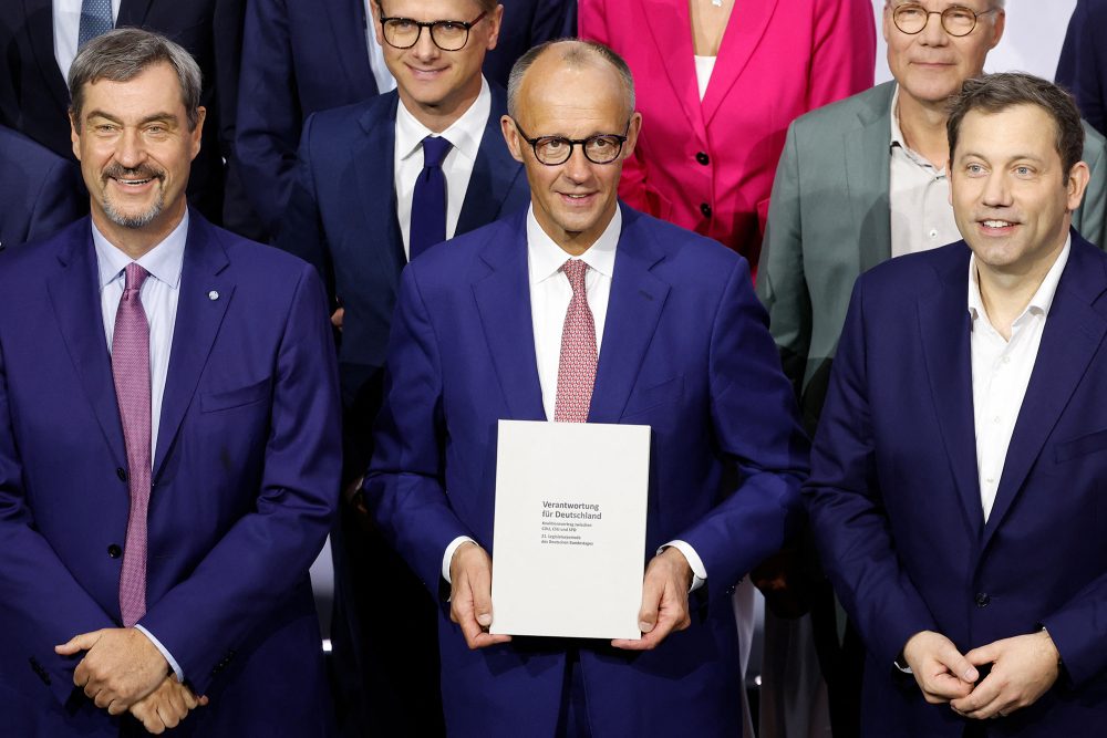 Der CDU-Vorsitzende Friedrich Merz mit dem Koalitionsvertrag in den Händen, der SPD-Co-Vorsitzende Lars Klingbeil und der CSU-Vorsitzende Markus Söder posieren mit Mitgliedern des neuen Kabinetts und Parteifunktionären für ein Gruppenfoto