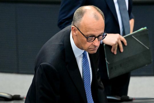 Friedrich Merz schaut sichtlich enttäuscht drein, als er sich nach dem verlorenen ersten Wahlgang von seinem Stuhl im Bundestag erhebt