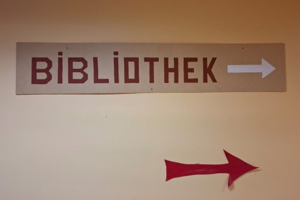 Schild und Hinweispfeil "Bibliothek" in der alten Schule in Hünningen