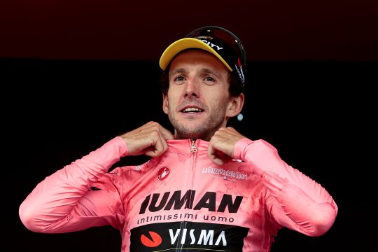 Simon Yates streift sich das Rosa Trikot über