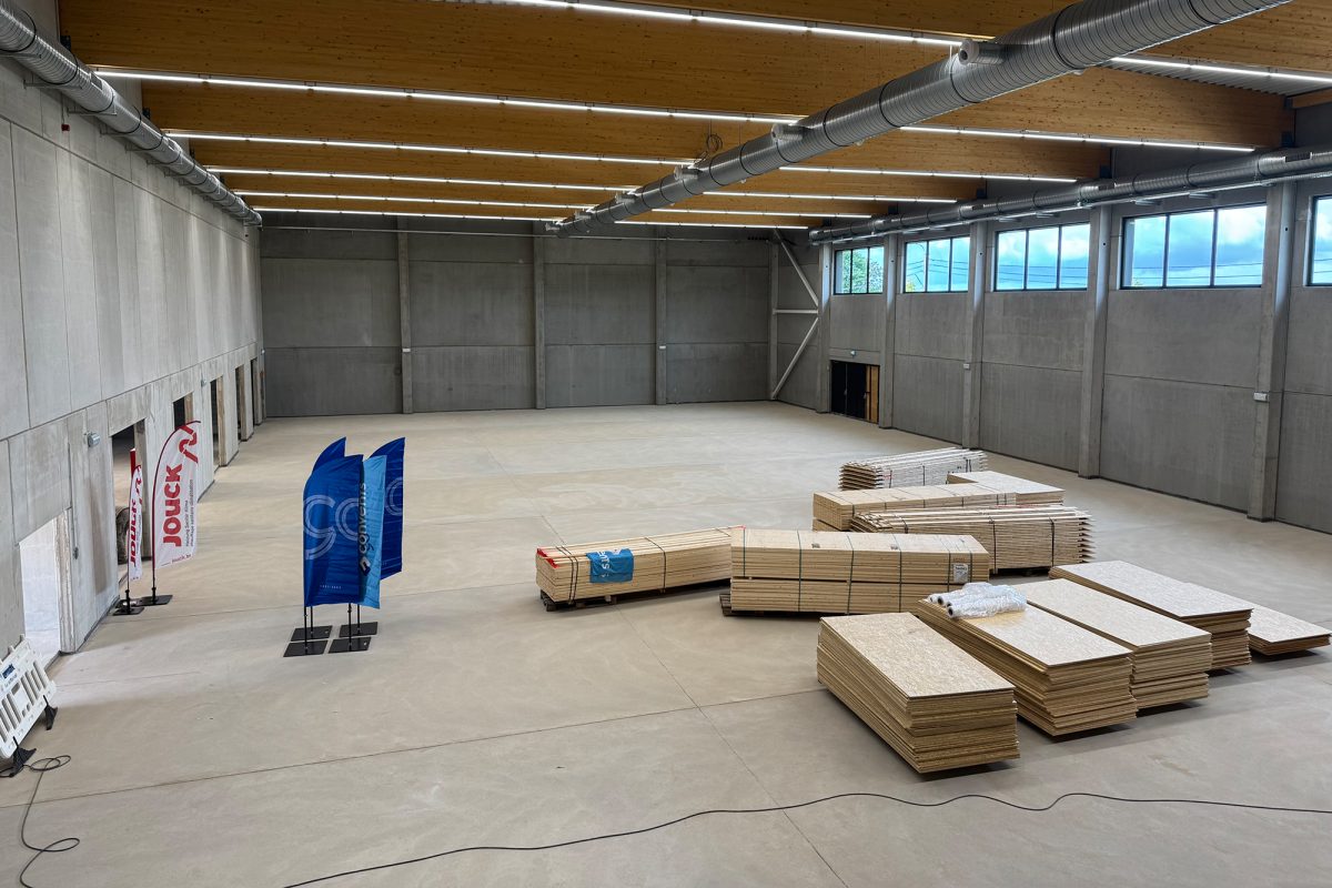 Die Sporthalle im neuen Sportkomplex auf Schönefeld, in der Mitte der Halle liegen palettenweise große Holztafeln