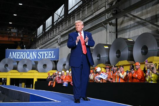 US-Präsident Donald Trump applaudiert während seiner Rede in einem Stahlwerk, rechts neben ihm sind Stahlarbeiter hinter einer Absperrung und hören ihm zu