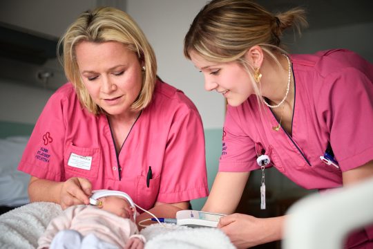 Kinderpflegerinnen kümmern sich um ein Neugeborenes