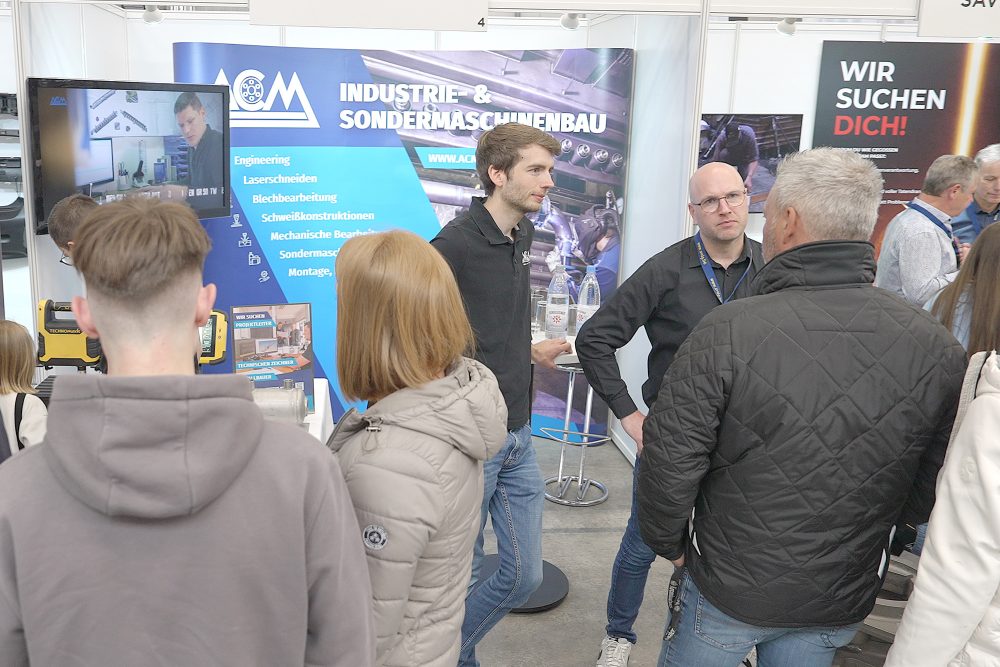 Besucher der Veranstaltung "Zukunft Metall" an einem Messestand