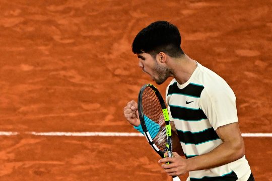 Carlos Alcaraz steht auf dem Tennisplatz und ballt jubelnd die Faust