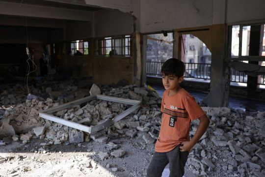 Ein palästinensisches Kind steht in dem zerstörten Klassenzimmer einer Schule, die als Notunterkunft diente