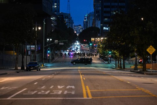 Eine weitgehend leere Straße des Nachts in Los Angeles, weiter hinten steht ein Polizeiauto quer und sperrt die Straße