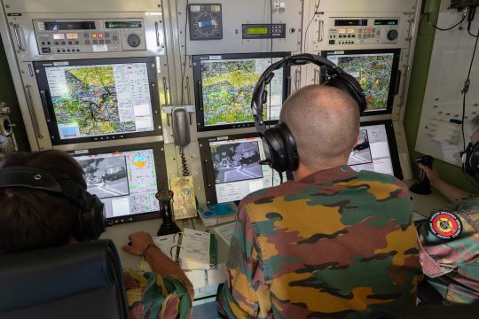 Kontrollstand für Drohnensteuerung mit mehreren Computermonitoren, zwei Armeeangehörige sind sitzend von hinten zu sehen