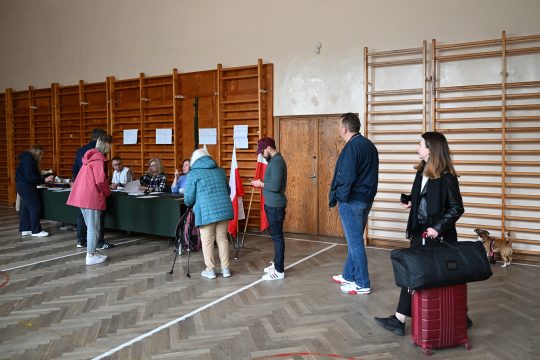 Menschen stehen Schlange in einem Wahllokal in Polens Hauptstadt Warschau