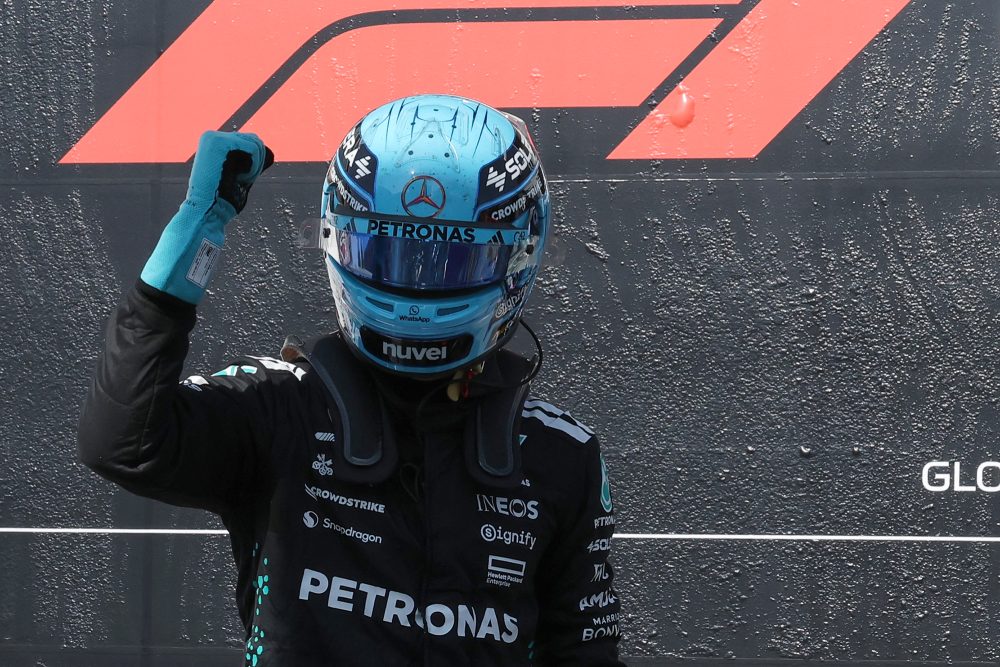 Mercedes-Pilot George Russell mit Helm auf dem Kopf reckt die Faust zum Jubel in die Höhe