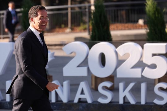 Mark Rutte geht zielstrebig und lächelt dabei, hinter ihm ein Teil des G7-Gipfel-Logos, zu sehen ist die Jahreszahl 2025 und ein Teil des Ortsnamens Kananaskis