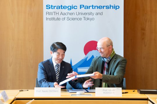 Professor Naoto Ohtake und Professor Ulrich Rüdiger signieren den Vertrag für die Strategische Partnerschaft