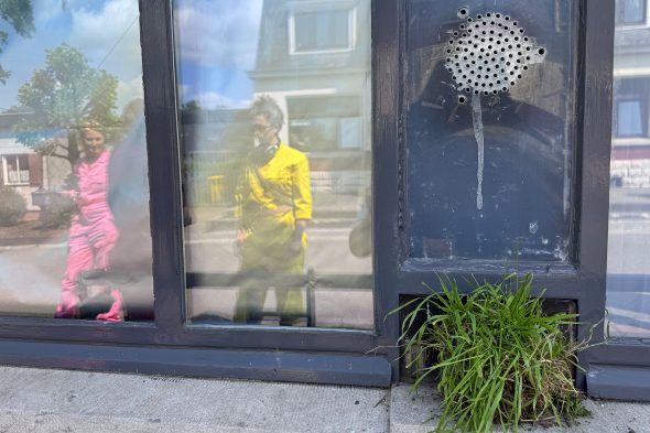 Nicole Erbe und Line Lerho spiegeln sich in der Scheibe des Zollhäuschens auf Köpfchen