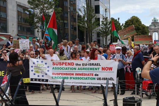 Ein Plakat fordert das Aussetzen des Assoziierungsabkommens mit Israel bei einem Protest gegen den Krieg in Palästina in Brüssel